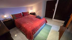 a bedroom with a bed with a red comforter at DaLu' tourist accommodation in Vallerano