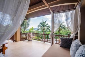 a room with a balcony with a view of the ocean at Bell Seaside Luxury Villa in Rawai Beach +46 photos