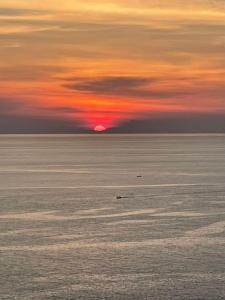 a sunset over the ocean with the sun setting at Bell Seaside Luxury Villa in Rawai Beach