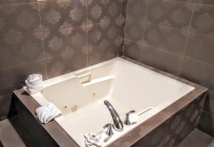 a bath tub with a sink in a bathroom at Gardena Terrace Inn in Gardena