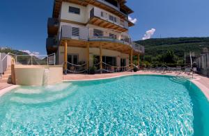a large swimming pool in front of a building at Ecohotel Primavera in Riva del Garda