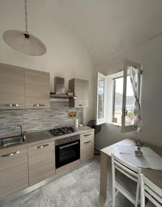 a kitchen with a stove and a table and a window at Appartamento LiboMarì in Favignana