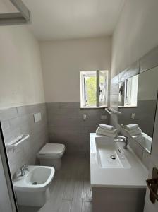 a white bathroom with a sink and a toilet at Appartamento LiboMarì in Favignana +9 photos
