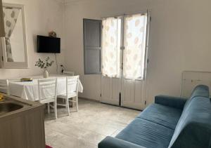a living room with a blue couch and a table at Appartamento LiboMarì in Favignana