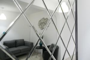 Zimmer mit Sofa und Spiegel in der Unterkunft In & Out Hotel in Guatemala