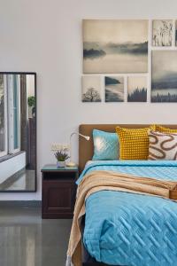a bedroom with a bed and pictures on the wall at SaffronStays Indigo House in Karjat +44 photos
