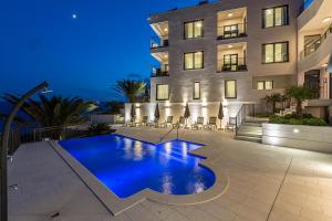 a swimming pool in front of a building at night at Villa Sky in Mimice