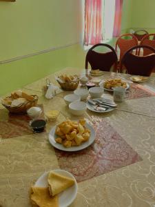 a table with plates of bread and bowls of food at Guest house Aidyn-Kul in Toguz-Bulak