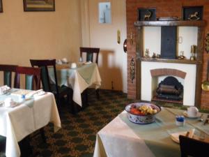a dining room with two tables and a fireplace at Bewdley Hill House in Kidderminster