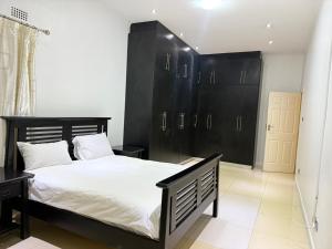a bedroom with a large bed with black cabinets at Lonehill Ridge in Blantyre