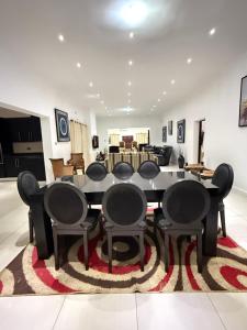 a dining room with a table and chairs on a rug at Lonehill Ridge in Blantyre