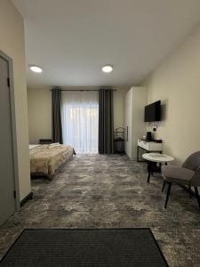 a hotel room with a bed and a television at Grey Hotel in Oral