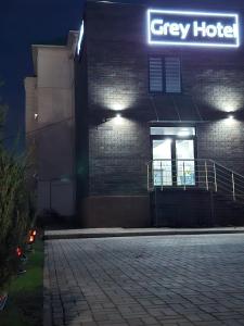 a grey hotel with a sign on the side of a building at Grey Hotel in Oral