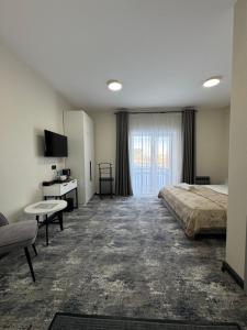 a hotel room with a bed and a window at Grey Hotel in Oral
