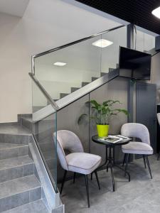a dining room with a table and chairs and stairs at Grey Hotel in Oral