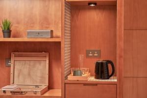 a kitchen with a coffee maker on a shelf at Oootopia Tai Kok Tsui in Hong Kong