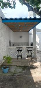 a patio with two benches under a blue umbrella at Casa Barcelona in Honda