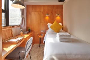 a bedroom with a bed and a desk and a bed at Oootopia Tai Kok Tsui in Hong Kong