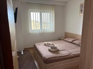 a bedroom with a bed with two towels on it at Gondola Mako Exclusive in Zlatibor