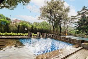 a swimming pool in a yard with a fence at Mountain View at The Edge in Cimindi-hilir