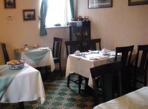 a dining room with two tables with white table cloth at Bewdley Hill House in Kidderminster