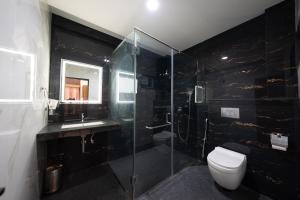 a bathroom with a shower and a toilet and a sink at Le Sea Sun in Pūrnānkuppam