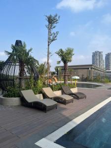 a group of lounge chairs next to a swimming pool at AnVy house Skyforest 2 Ecopark in Xuân Quan