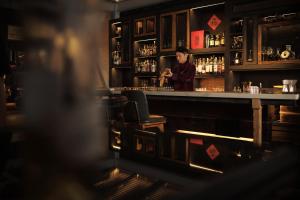 a woman standing behind a bar in a pub at Mandarin Oriental, Shenzhen in Shenzhen