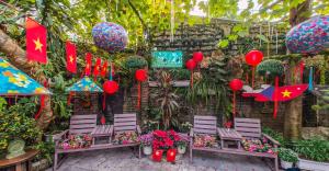 a garden with chairs and flags and plants at Oáza coffee & bar in Hanoi +4 photos