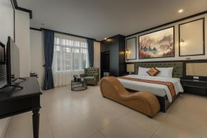 a bedroom with a large bed and a television at Royal Hotel & Spa in Ðồng Ky