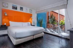a bedroom with a large white bed and a balcony at Hotel 104 Art Suites in Bogotá