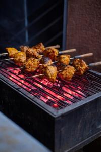 a bunch of food cooking on a grill at HEMGIRI - Private Pool Villa Mulshi in Mulshi