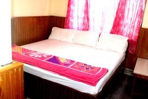 a bed in a room with a red curtain at Hotel Lhakhar in Gangtok