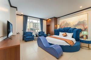 a bedroom with a large blue bed and blue chairs at Royal Hotel & Spa in Ðồng Ky
