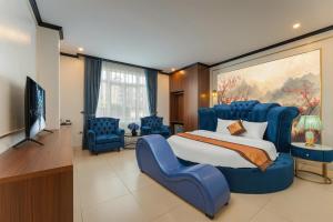 a bedroom with a large blue bed and blue chairs at Royal Hotel & Spa in Ðồng Ky