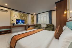 a hotel room with a large bed and a tv at Royal Hotel & Spa in Ðồng Ky