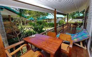 a porch with a wooden table and chairs on a deck at The Joy Beach Villas in Hinkong