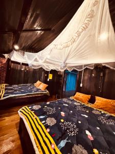 a bedroom with two beds and a mosquito net at Sisi House Experience Hike & Batik Painting in Sa Pả