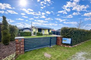 a house with a blue fence in a yard at Ferienbungalow Muranko am Kiessee in Krugsdorf