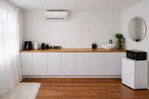 a kitchen with white cabinets and a counter with a sink at Blagdon Close Guesthouse in New Plymouth