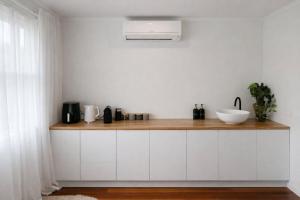 a kitchen with white cabinets and a counter with a sink at Blagdon Close Guesthouse in New Plymouth