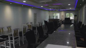 a room with tables and chairs and purple lights at bethi farms in Malkāpur