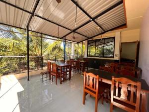 a restaurant with wooden tables and chairs and windows at SAHAY VILLA RESORT in Durbate
