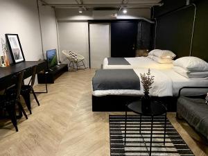 a bedroom with two beds and a table and a desk at Bedsment in Chiang Rai
