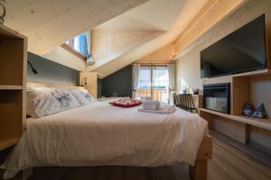 a bedroom with a large white bed with a large window at Appartamenti Casa Sabry in San Niccolò Comèlico
