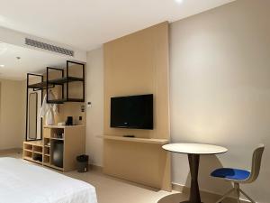 a bedroom with a bed and a table and a tv at Arena Oceanview Cam Ranh - Infinity swimming pool in Cam Ranh International Airport
