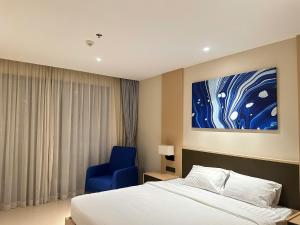 a hotel room with a bed and a blue chair at Arena Oceanview Cam Ranh - Infinity swimming pool in Cam Ranh International Airport +68 photos