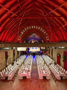 a banquet hall with white tables and pink chairs at Hotel Kloster Nimbschen 4 Sterne in Grimma