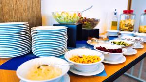 a buffet with plates and bowls of food on a table at OZO George Town Penang in George Town