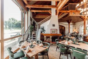 a dining room with wooden tables and green chairs at Hotel Kloster Nimbschen 4 Sterne in Grimma